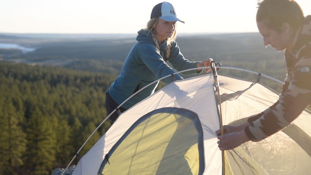 women-assembling-tent-on-mountain-in-colorado